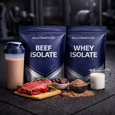 NULTRAFITUK beef isolate and whey isolate protein powders with shaker bottle, milk and protein ingredients displayed on a rubber gym floor in a dark gym environment.
