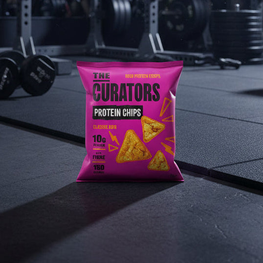 Pink packaging of 'The Curators' protein chips bag on a gym floor