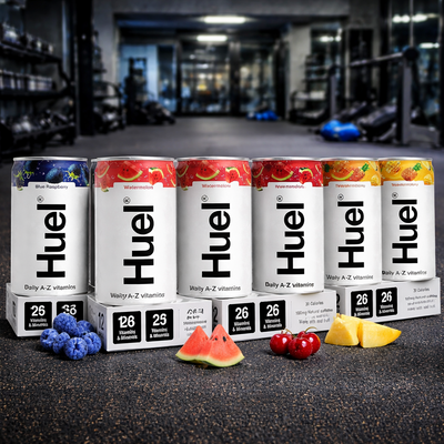 HUEL Daily A-Z Vitamin Cans on a gym floor