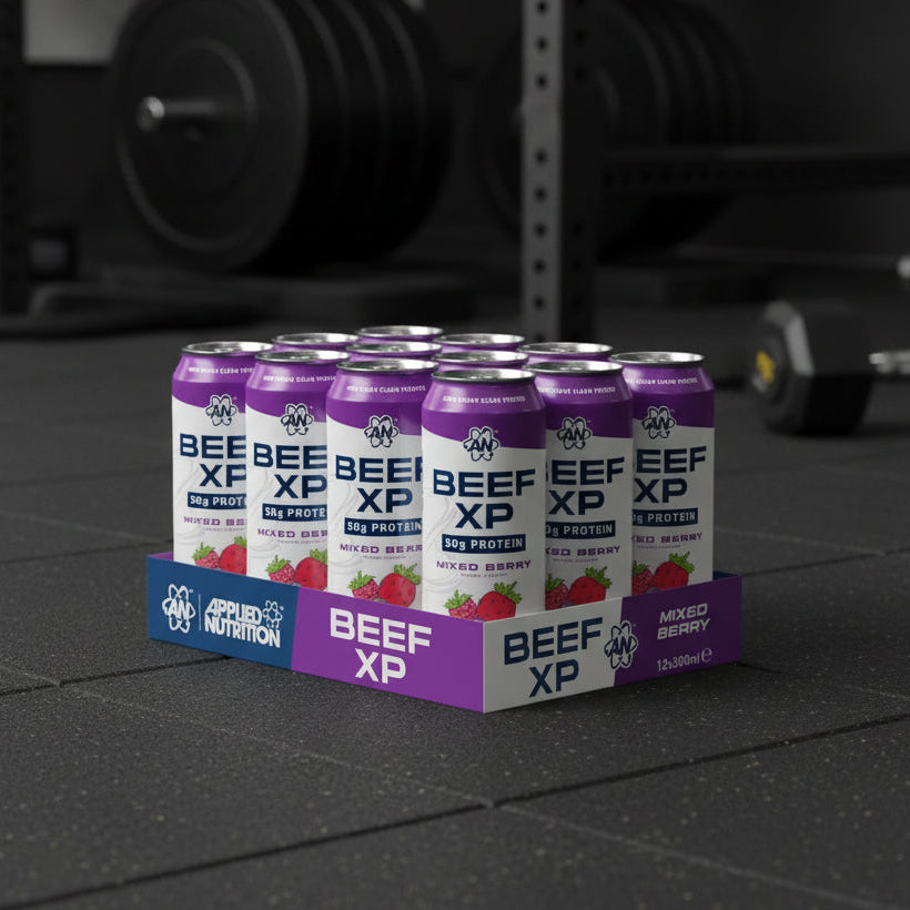 Beef XP protein cans and packaging on a gym floor with weights in the background