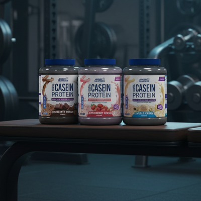 Three containers of casein protein powder with different flavors on a dark background.