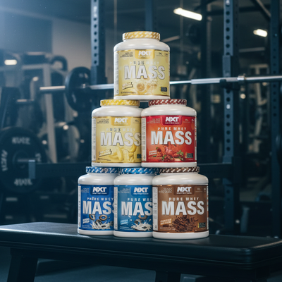 Stack of NXT Pure Whey Mass protein powder containers in various flavors.