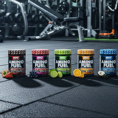 Row of Amino Fuel supplement containers on a gym floor with gym equipment in the background.