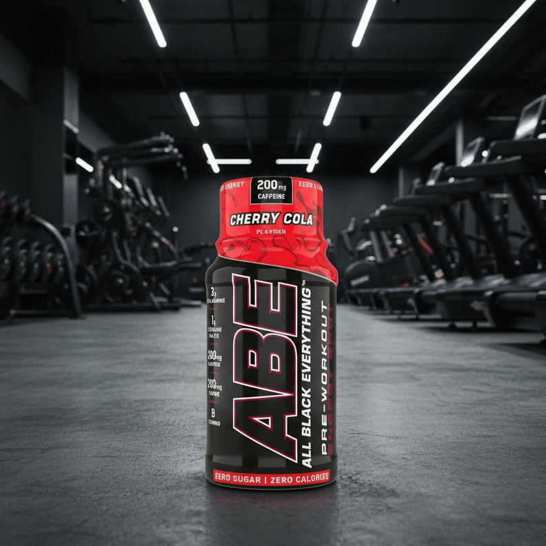 ABE All Black Everything pre-workout supplement bottle with cherry cola flavor on a gym background