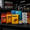Assorted health and fitness food products on a table with a gym background.