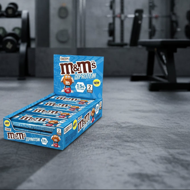 Box of M&M's High Protein candy bars on a gym background