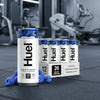 HUEL Daily A-Z Vitamin blue raspberry 
flavour Cans on a gym floor
