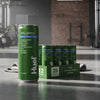 Huel Daily Greens Cans Blueberry, Lemon & Thyme Flavour on a gym floor.
