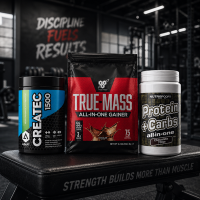 Three supplement packages on a black surface with gym background