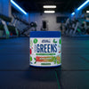 Applied Nutrition Critical Greens container with apple burst flavour on a gym background