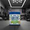 Applied Nutrition Critical Greens supplement container on a gym background