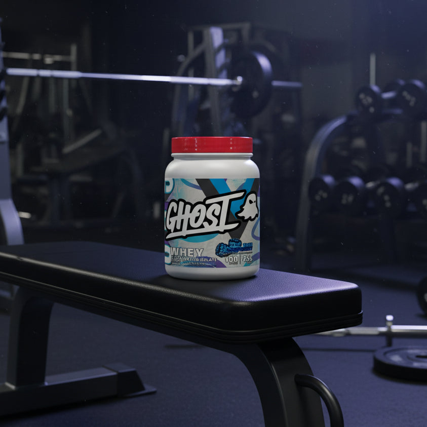 A white plastic tub of Ghost Whey Clear Protein Isolate in Blue Raspberry flavor, featuring a bright red lid and a colorful label with a ghost logo.