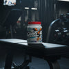 A white plastic tub of Ghost Whey Clear Protein Isolate in Orange Cream flavor, featuring a bright red lid and a colorful label with a ghost logo.