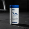 Supplement container labelled 'CLA+ L-Carnitine & Green Tea' by Applied Nutrition on a gym background