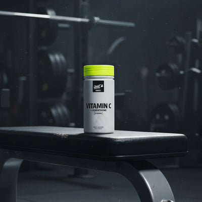 Supplement bottle labelled 'Vitamin C + Glutathione' with a yellow cap on a gym bench, featuring the Kong and Ghost Supplements logos.