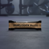 Barebells Caramel Cashew protein bar on a gym background