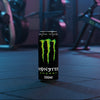 Monster Energy drink bottle on a gym floor with equipment in the background