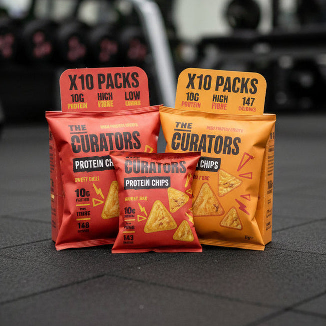 Protein snack packages on a gym floor with blurred gym equipment in the background
