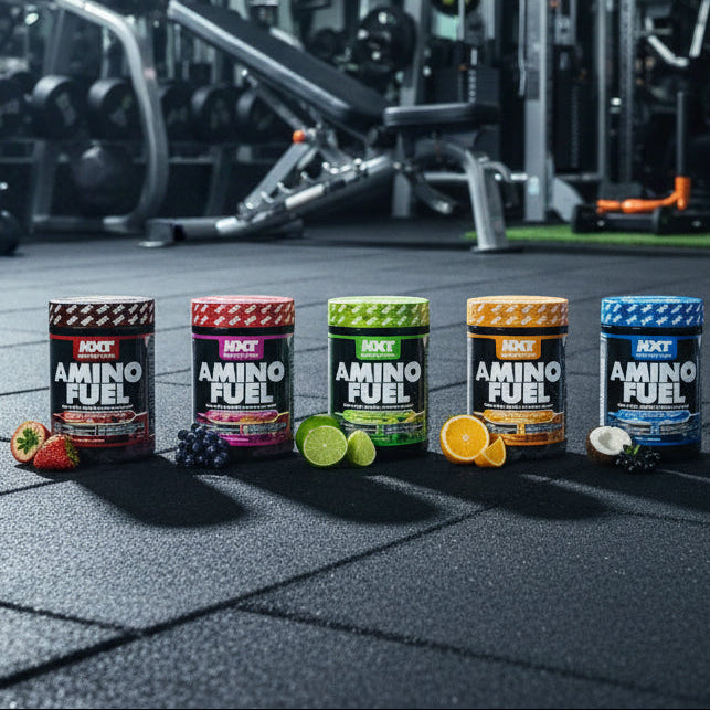 Row of Amino Fuel supplement containers on a gym floor with gym equipment in the background.