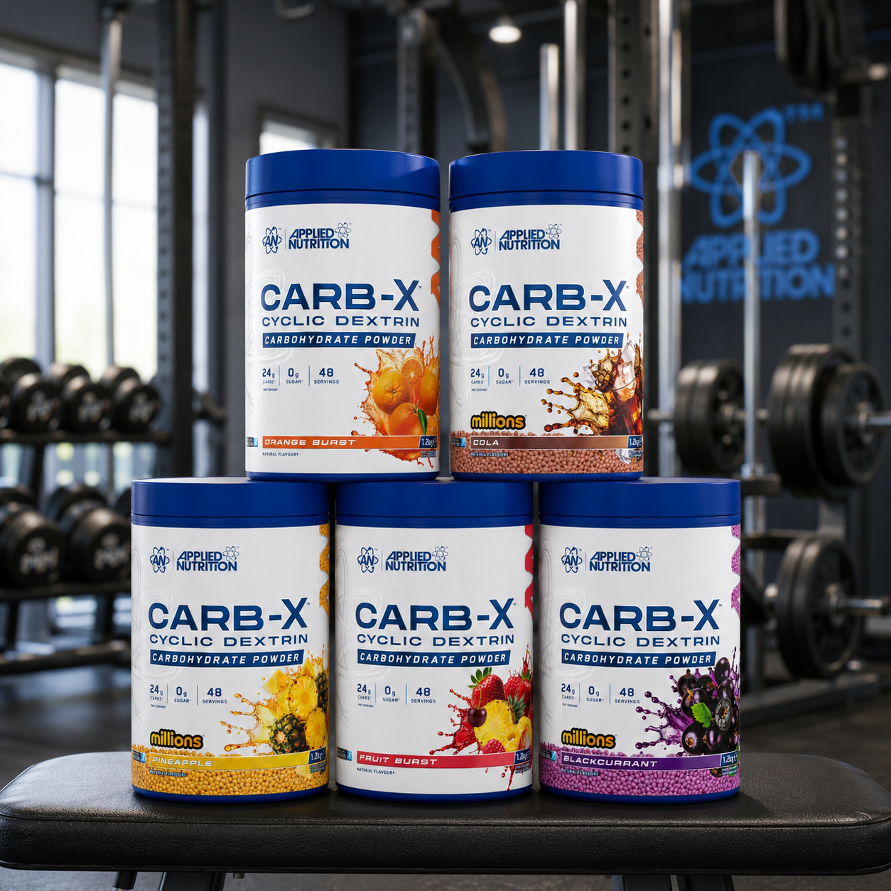 Five containers of Applied Nutrition CARB-X powder on a gym bench with gym equipment in the background.