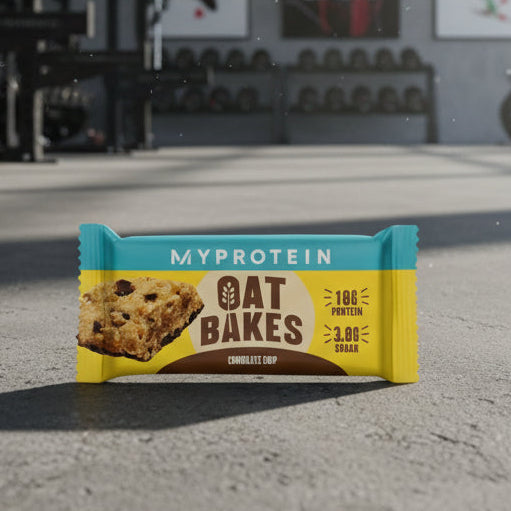 MyProtein oat bake bar on a concrete surface with gym equipment in the background
