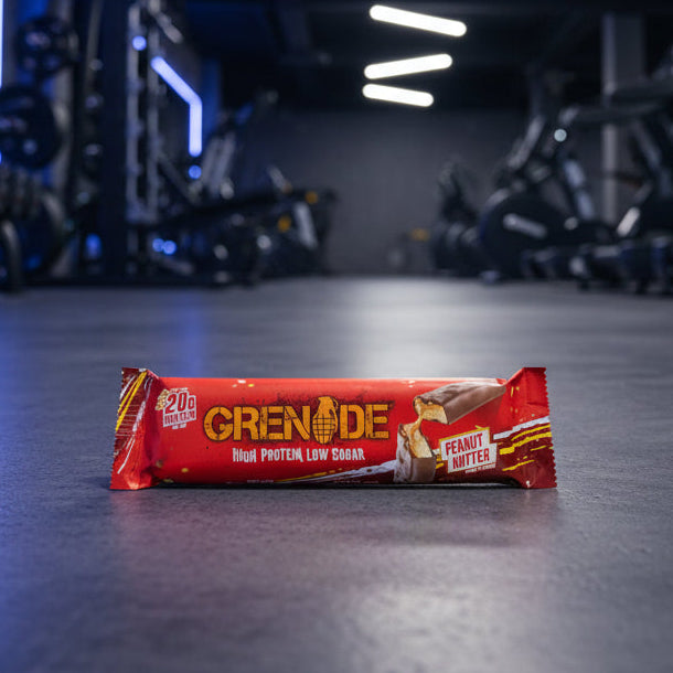 Grenade protein bar on a gym floor with equipment in the background