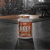 Beef protein isolate container on a gym floor with equipment in the background