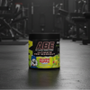 Pre-workout supplement container with ABE and Slush Puppie branding on a gym background
