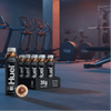 Huel chocolate peanut butter protein bottles with packaging on a gym background