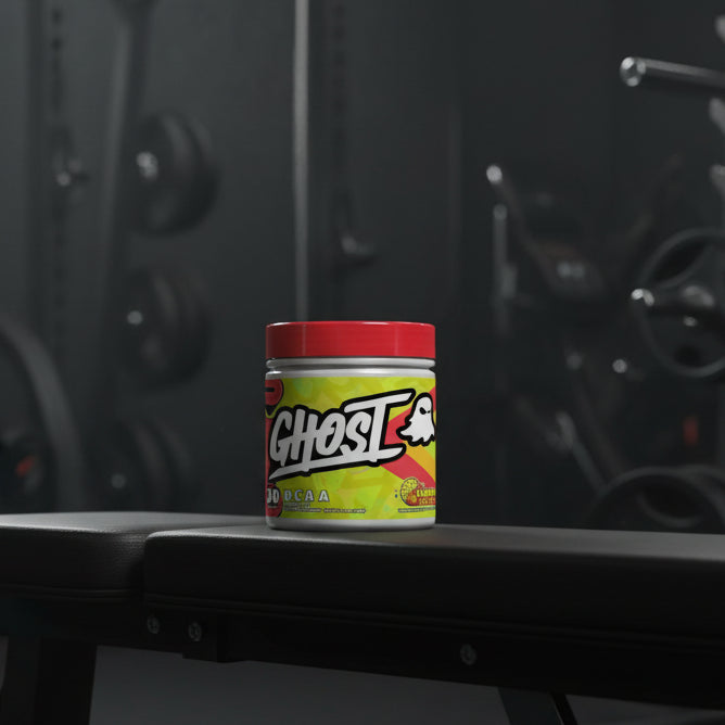 Ghost BCAA supplement container with colourful label on a gym background