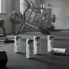 Red Bull energy drink cans on a gym floor with exercise equipment in the background