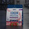 Package of Applied Nutrition 100% Casein Protein in Strawberry Cream flavour on a gym background