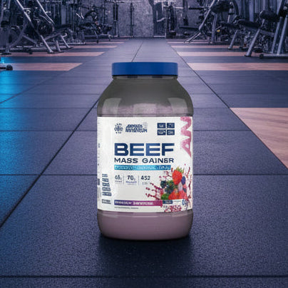 Beef mass gainer supplement container with Applied Nutrition branding on a gym background